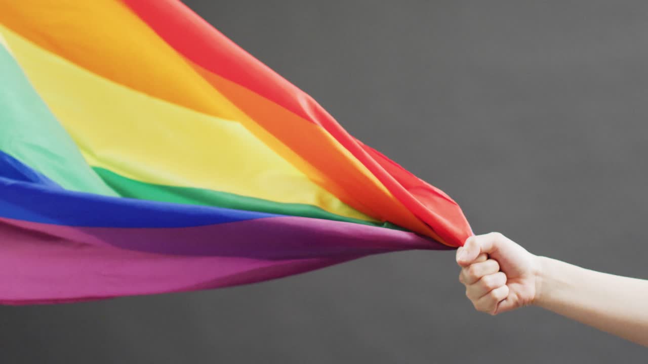 video de la mano del hombre caucásico con la tela del arco iris