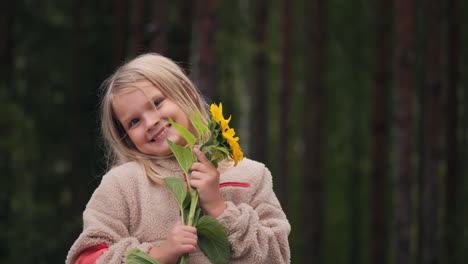 Handheld,-slow-motion-portrait-shot-of-a-young-blonde-girl-smiling-and-showing-a-flower,-Helsinki-Finland