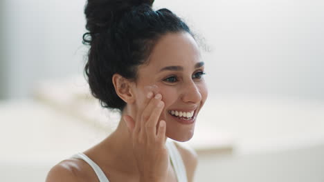 mujer aplicando crema facial