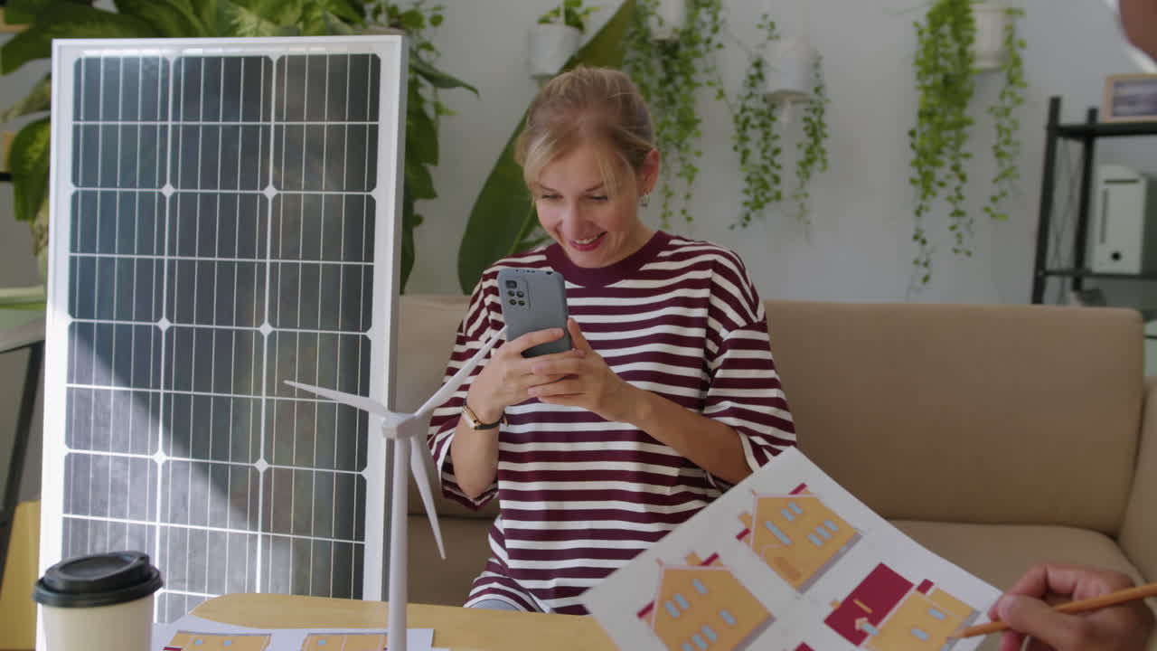 Woman Taking Photo of Wind Turbine Visiting Office of Sustainable Solutions