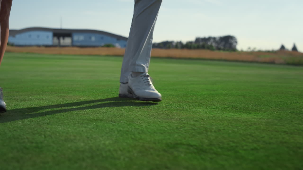 골프 커플 다리가 코스 잔디를  ⁇ 고 있습니다. 두 부유한 사람들이 컨트리 클럽을 산책