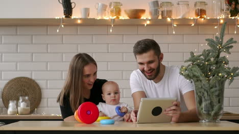 Familie-Aus-Mutter,-Vater-Und-Baby-Sitzt-Zu-Hause-Mit-Einem-Tablet-PC