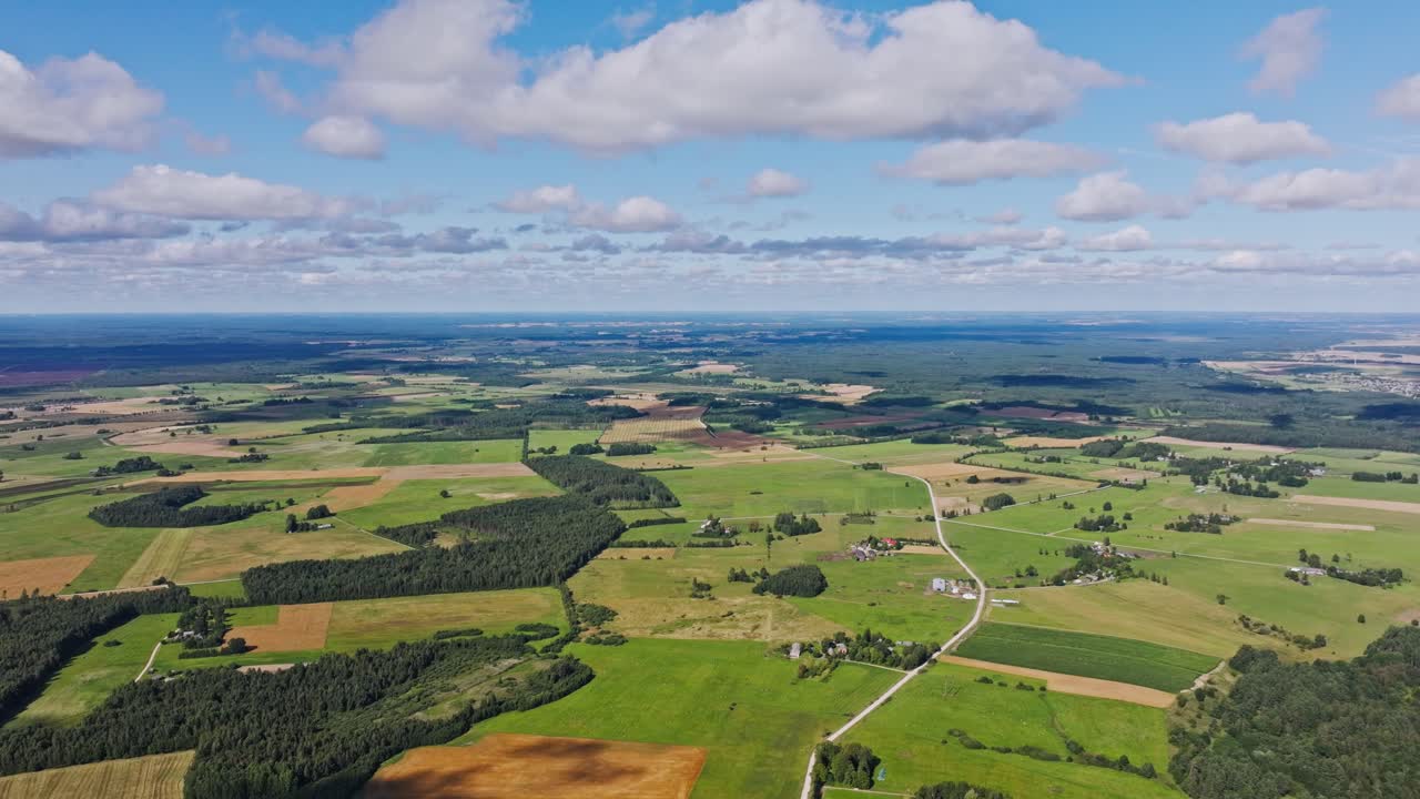 Peaceful aerial scene of green meadows and farmland stretching to the horizon