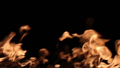 Fire-flames-shimmering-and-dancing-against-black-background