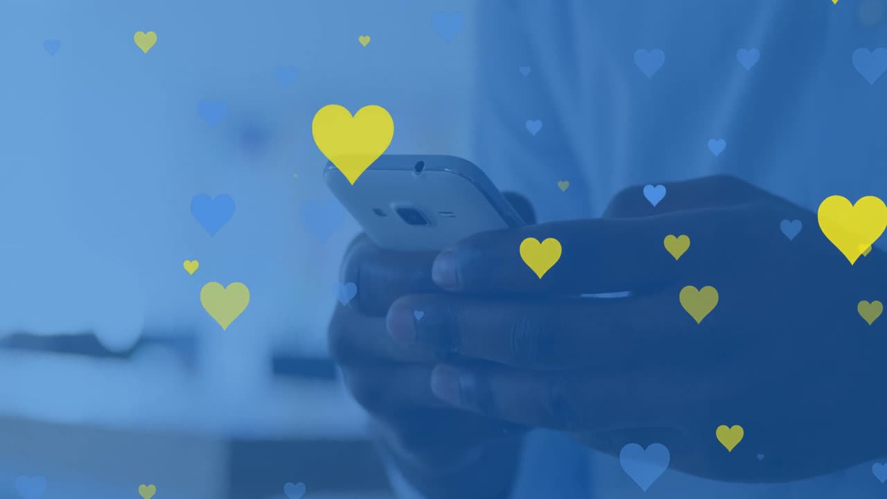 Animaatio keltaisista ja sinisistä sydämistä leijumassa monirotuisen miehen käsien yllä, tämän käyttäessä älypuhelinta.