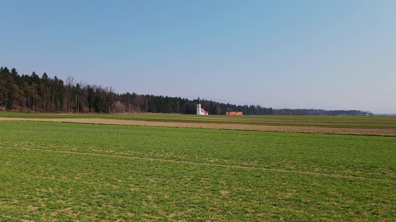 дрон с контрастными текстурами поля, церковь святого иакова в словении, весна, 4к