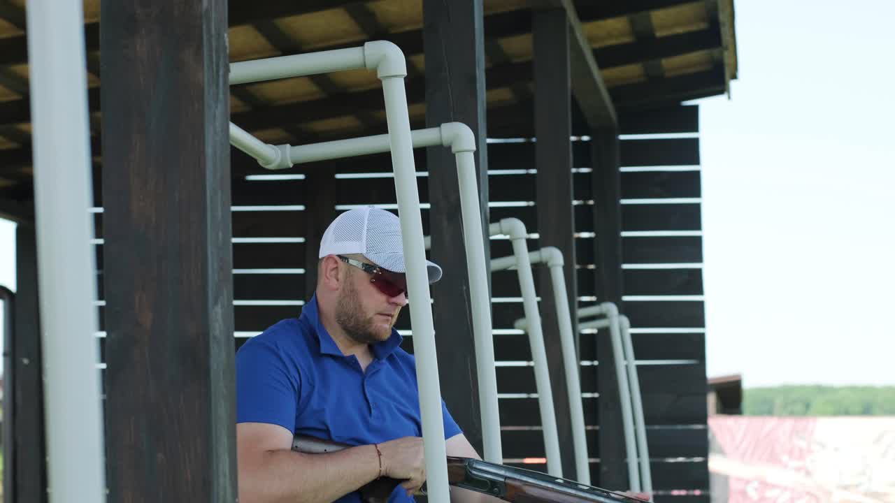 un deportista dispara con una escopeta de doble cañón, un campo deportivo para una prueba de tiro está disparando a un esquete volador