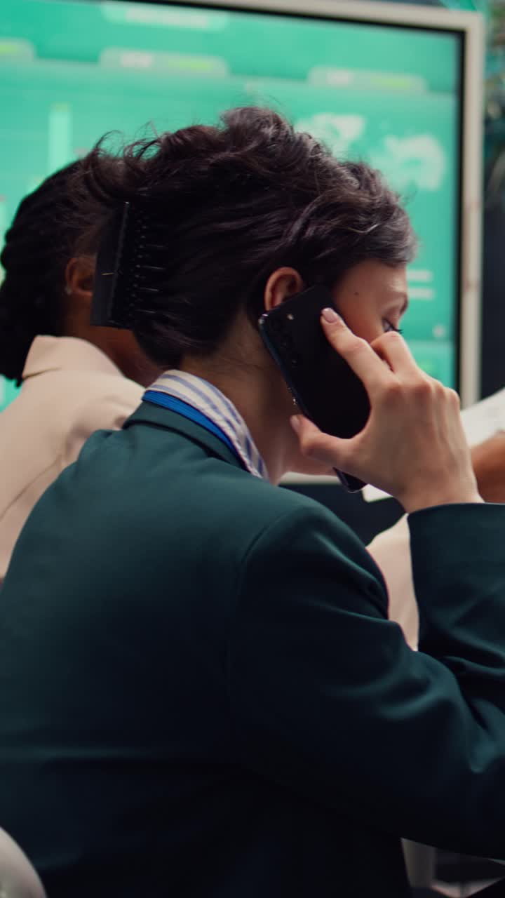 Businesswoman Talking on Phone While Working on Laptop in Office