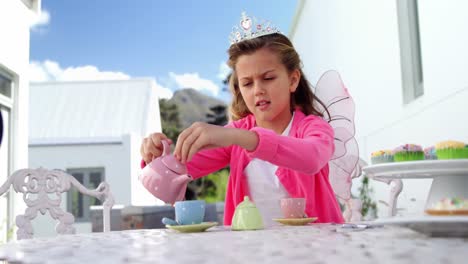 Girl-in-fairy-costume-pouring-tea-into-cup-4k