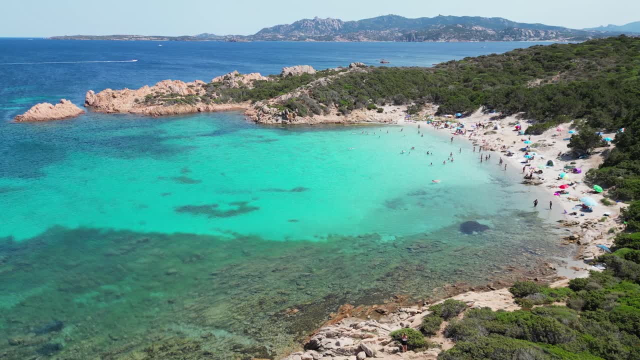 Île de La Maddalena, Caprera, Sardaigne - Touristes nageant et se relaxant à la plage de Cala Andreani et dans la baie bleue - Aérienne 4k en cercle