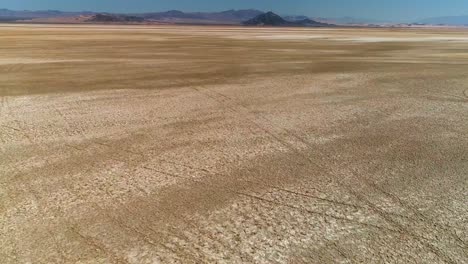 aerial view of backwards fast flight over desert salt flats