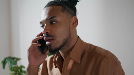 attentive guy speaking smartphone room closeup. contemporary man calling mobile