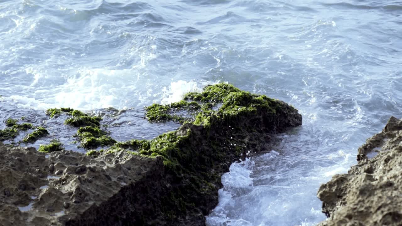 바다의 파도가 바위가 있는 해변에 부히고