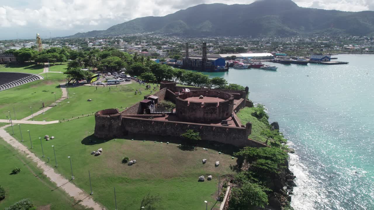 Orbita aerea cinematografica della Fortezza coloniale di San Felipe a Puerto Plata. Presenta la costa, l'architettura storica e il porto per navi da crociera