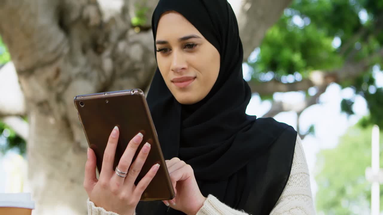 mujer con hijab usando tableta digital 4k