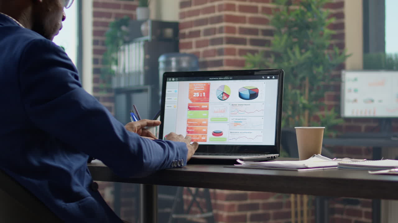 Research consultant analyzing business charts and graphs on laptop
