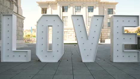 big white love prop letter wedding decoration in front of sunny building