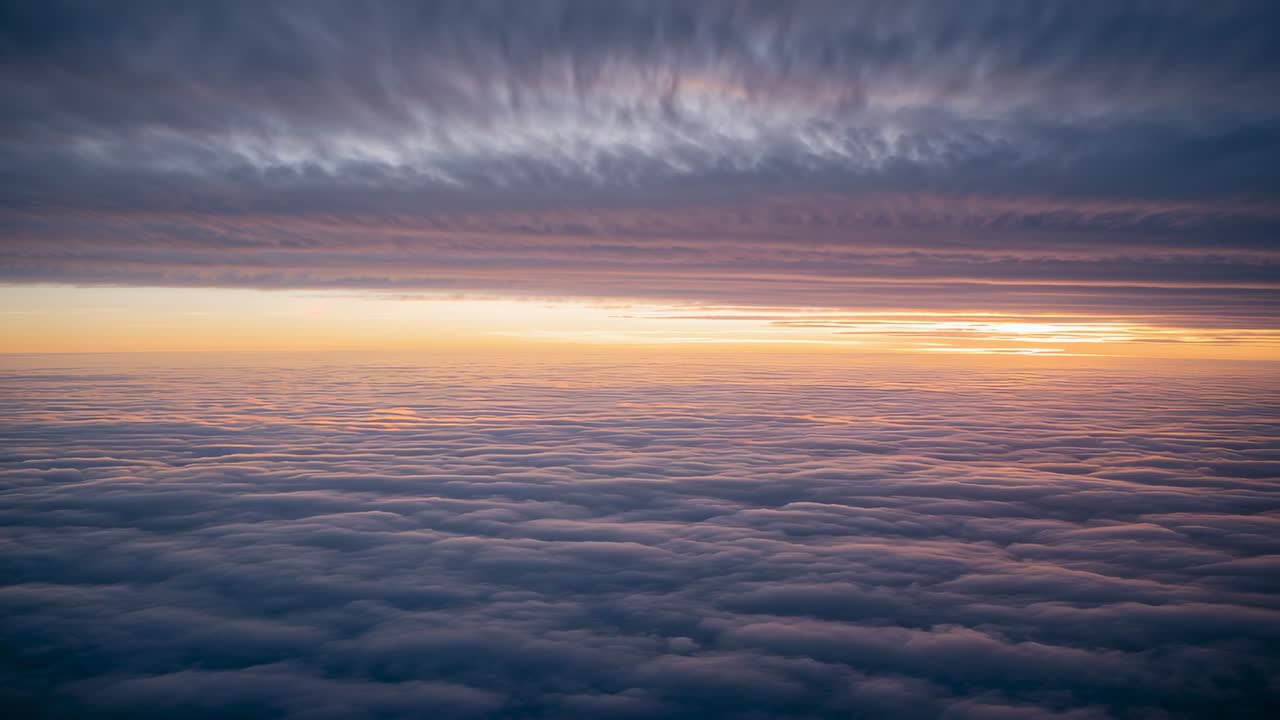 La luce del sole nascente illumina lo strato di nubi ad alta quota all'alba, evidenziando il bagliore all'orizzonte
