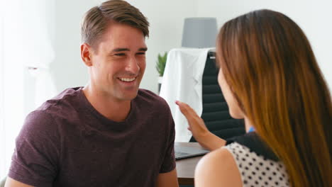 smiling man being given good health news at appointment with female doctor or gp in office