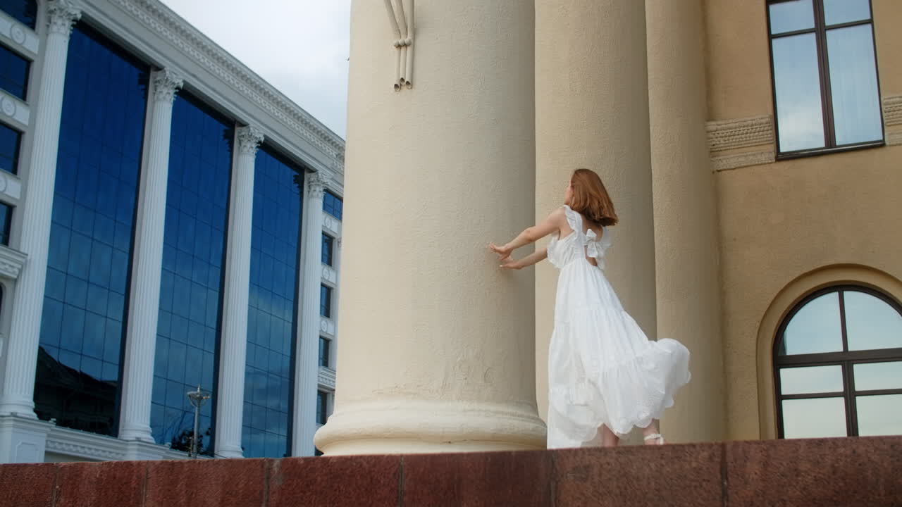 Woman in white dress in front of historical building
