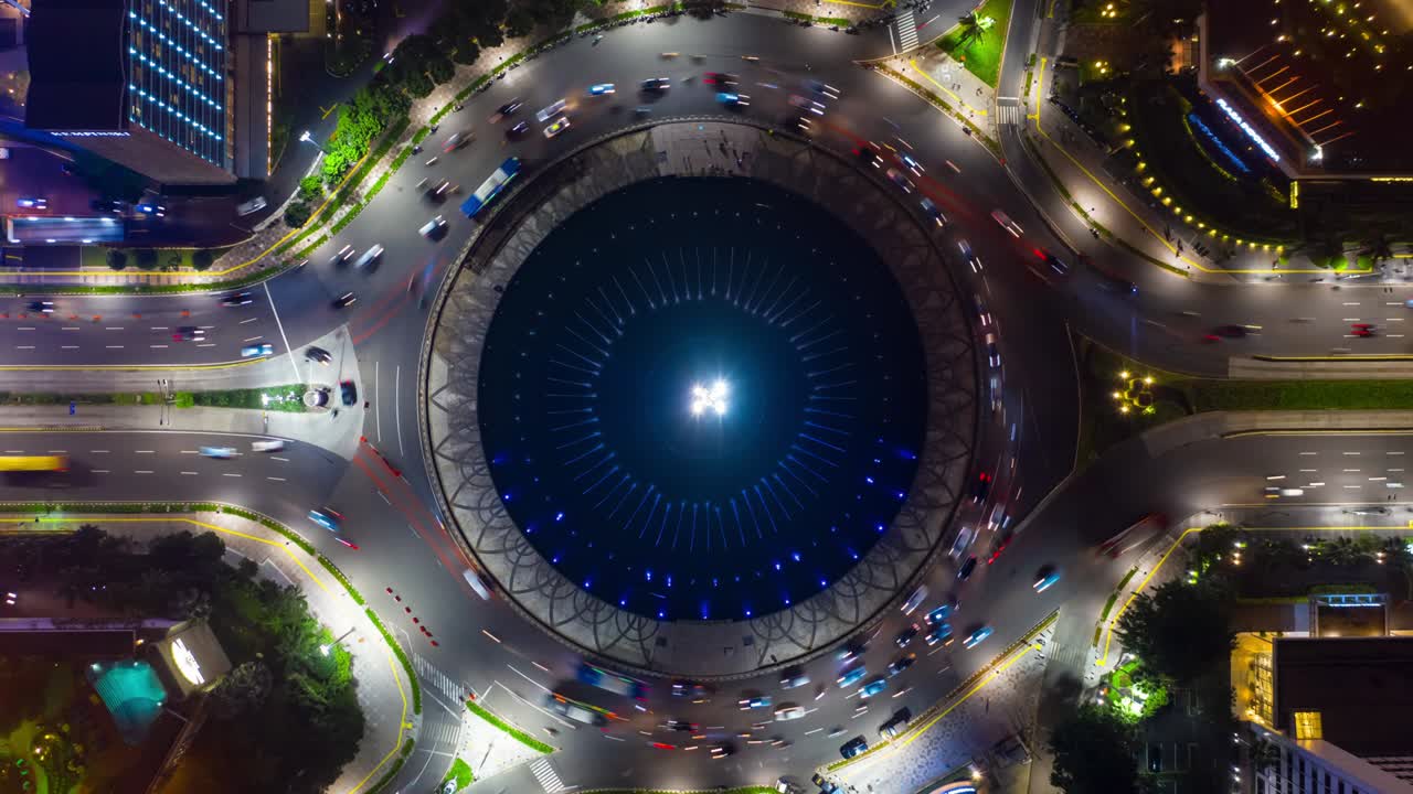 iluminación nocturna de la ciudad de yakarta la calle principal de tráfico de yakarta el círculo de la fuente el panorama aéreo de arriba hacia abajo 4k indonesia