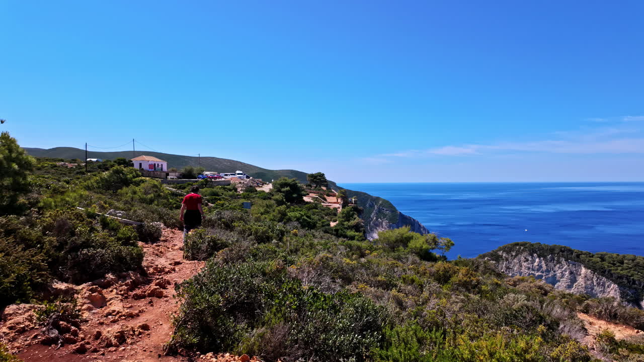 fotografía en cámara lenta de una persona caminando por un sendero costero en el punto de vista de navagio