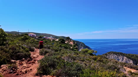 Slow-motion-shot-of-a-person-hiking-a-coastal-trail-in-Navagio-viewpoint