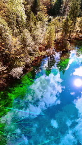 stunning view of a lake reflecting blue sky on summer day. aerial perspective on christlessee lake, oberstdorf, bavarian alps, europe. vertical video.