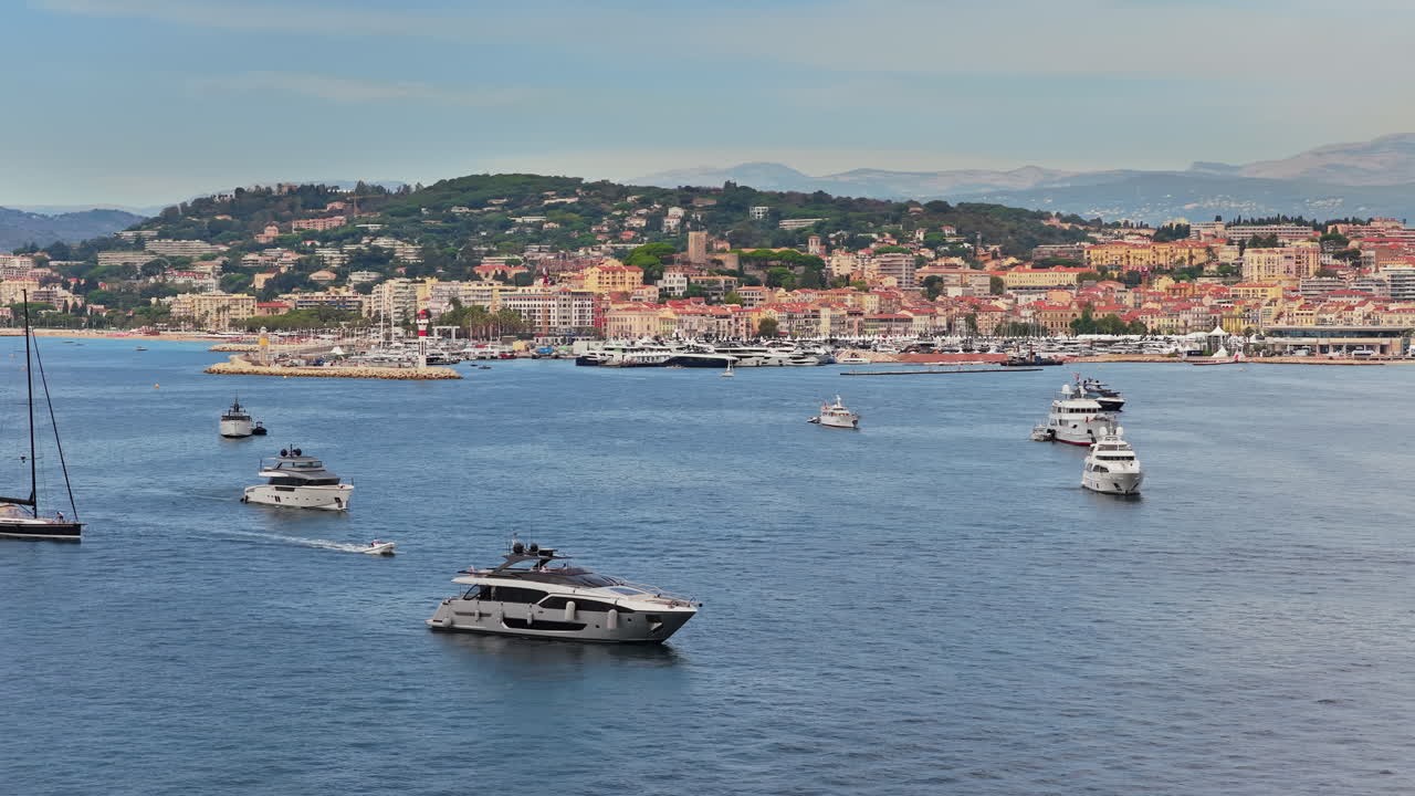 Vista aerea da drone di yacht di lusso ancorati al largo con il Palais des Festivals e lo skyline della città di Cannes sullo sfondo