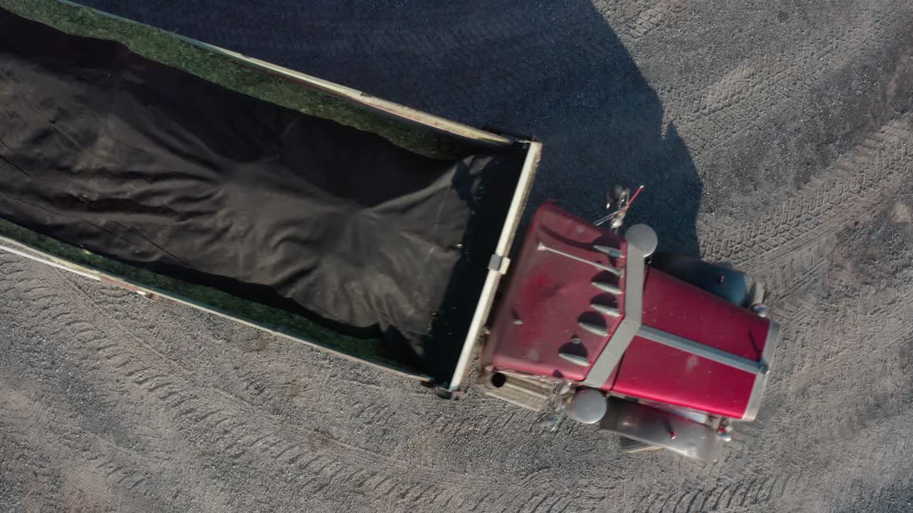 Top down aerial of truck backing up on gravel driveway, leaving tire tracks