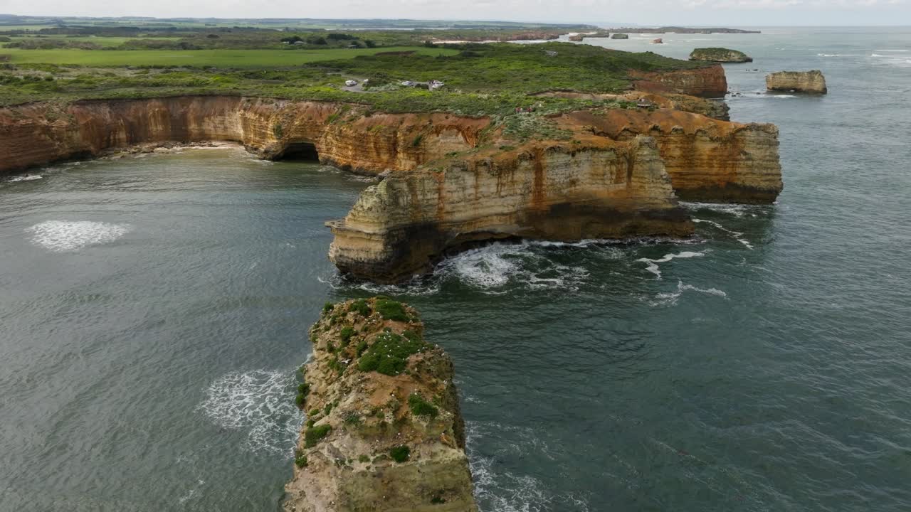 vista aérea de los acantilados de la gran carretera del océano como gaviotas están volviendo a su nido en un día nublado