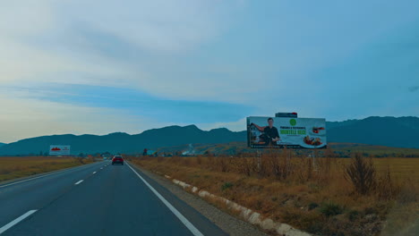 driving by the speedway through the valley. silhouette of mountain range at backdrop.