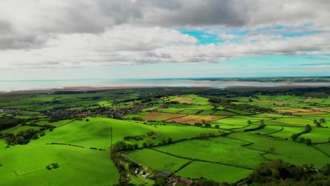 aerial wide landscape of the rural farmland in the english lake district, bright blue sky day