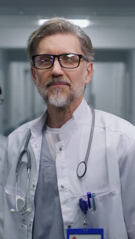 Mature doctor stands in clinic corridor looks at c 4k 2025 07 22 04 29 00 utc.mov | assistance, background, care, caucasian