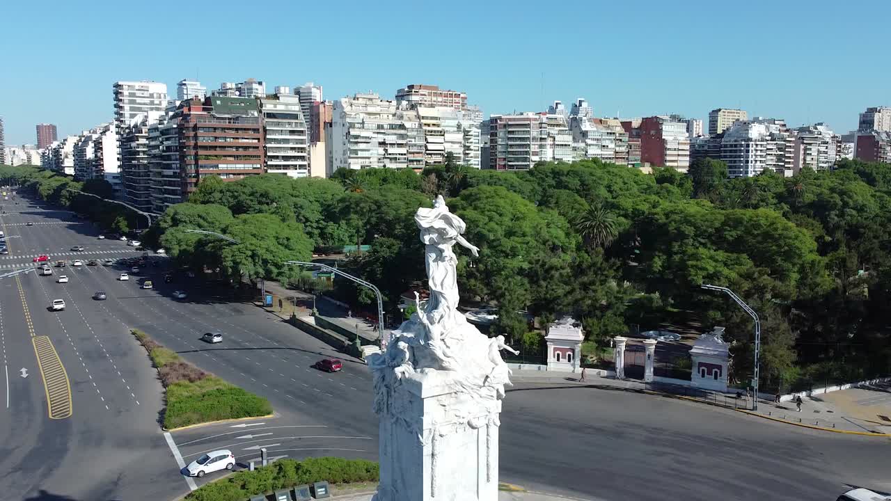 monumento de mármol rodeado de grandes avenidas, parques y edificios verdes, en buenos aires