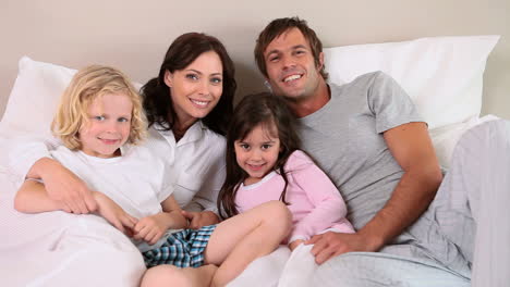 smiling family lying in a bed