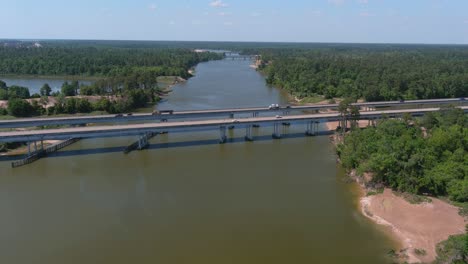 Aerial-of-cars-driving-on-bridge-that-crosses-over-the-San-Jacinto-River-in-Houston,-Texas