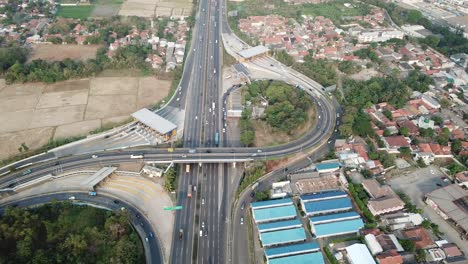 aerial view of highway intersection with toll booth and cityscape