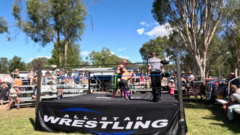 wrestlers compete in an outdoor wrestling ring