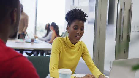 Colegas-De-Negocios-Afroamericanos,-Hombres-Y-Mujeres,-Hablando-Y-Usando-Una-Computadora-Portátil-En-La-Oficina