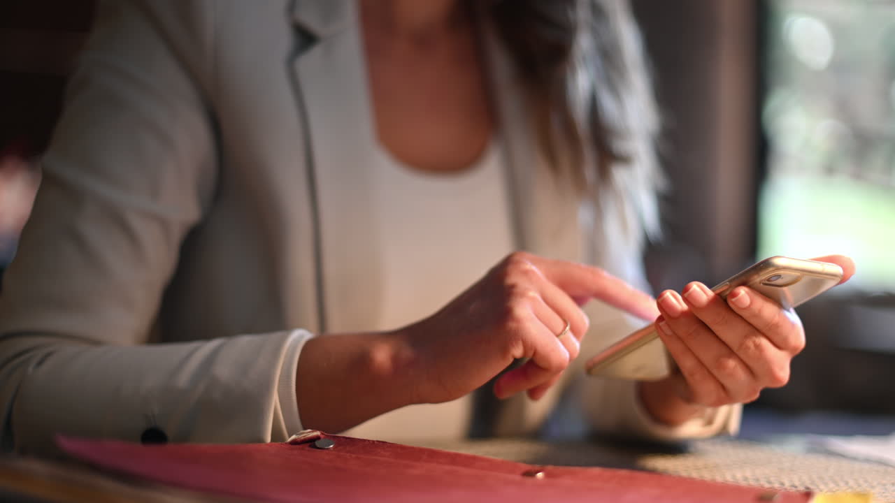 Kvinde, der arbejder på mobiltelefon på en restaurant