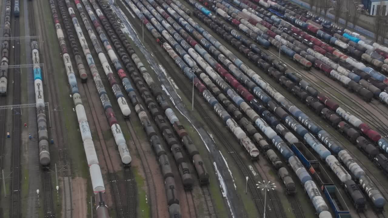 Züge stehen auf einem großen Abstellgleis in einem Verkehrsknotenpunkt bei Tageslicht.