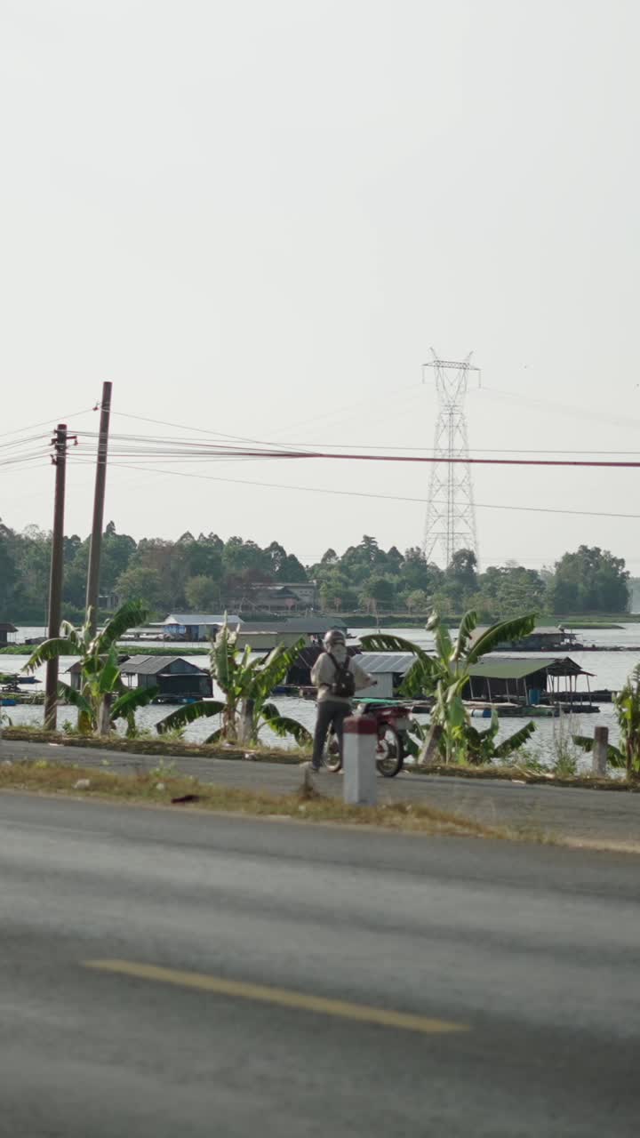 Motorcycle on a road near houses on water