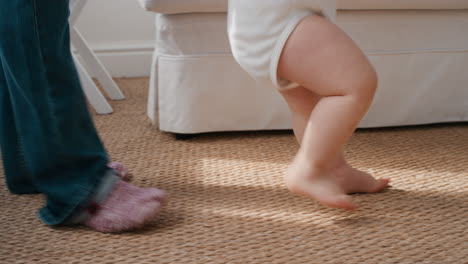 baby taking first steps toddler learning to walk with father helping infant teaching child at home fatherhood support