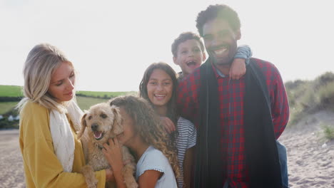 Porträt-Einer-Aktiven-Multikulturellen-Familie-Mit-Hund-Im-Winterstrandurlaub