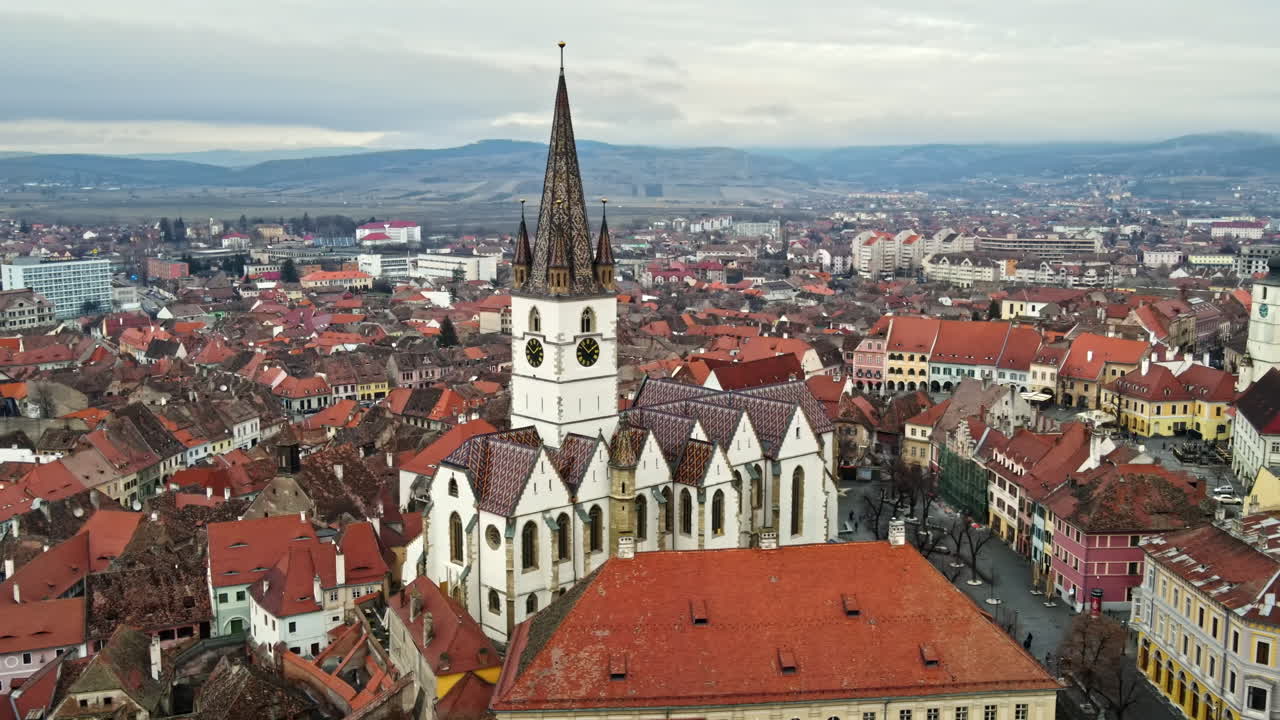 Vista aerea da drone della cattedrale luterana di Sibiu in Romania. Strada con alberi spogli, numerosi edifici, paesaggio urbano