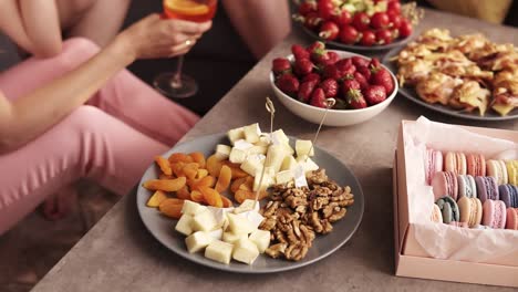 close up footage of some snacks for the hen party. a luxurious way of life. macaroons, canap , strawberry on a wooden coffee table