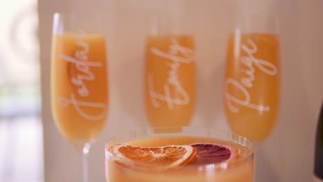 Orange-And-Champagne-Alcoholic-Drinks-With-Names-Printed-On-Glasses