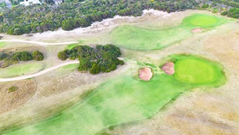 drone footage captures lush golf course and scenic coastline in barwon heads, victoria, under soft daylight