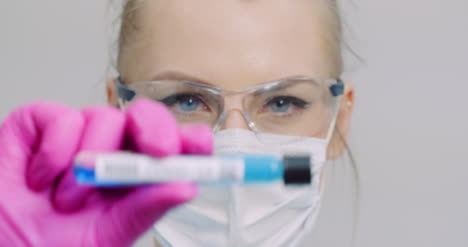 researcher holding covid 19 sample tube in hand 2